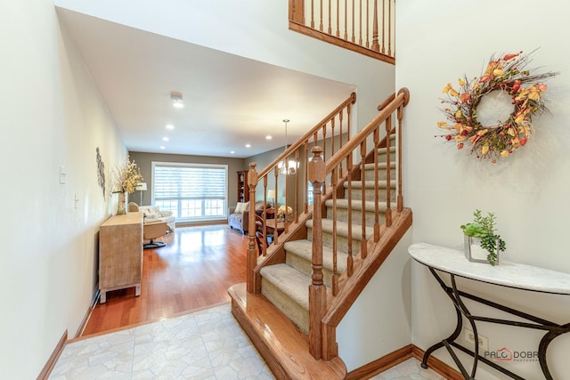 stairway with wood finished floors, recessed lighting, and baseboards