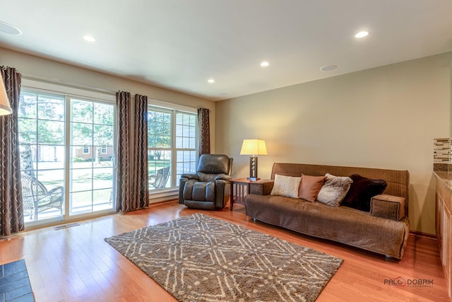 living room with recessed lighting, wood finished floors, and visible vents