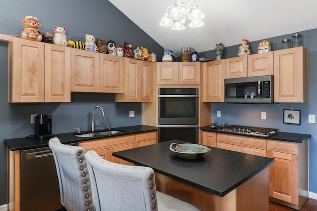 kitchen featuring dark countertops, light brown cabinets, stainless steel appliances, and a sink