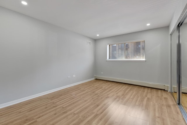 unfurnished bedroom with light wood-type flooring, a baseboard radiator, baseboards, and recessed lighting