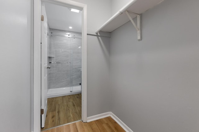 walk in closet with wood finished floors