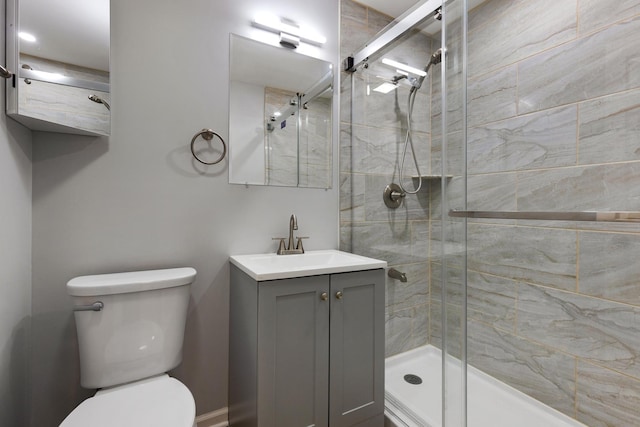 full bathroom with toilet, a stall shower, and vanity