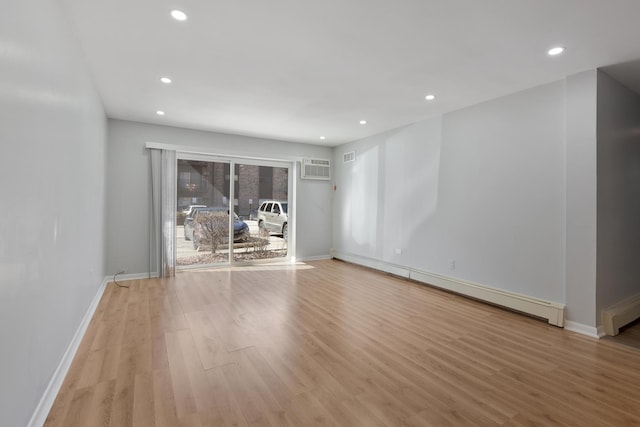 unfurnished room featuring light wood-type flooring, a baseboard heating unit, baseboards, and recessed lighting