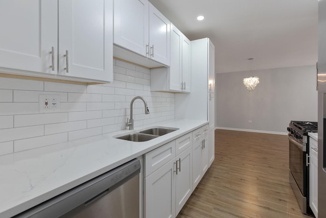 kitchen featuring decorative backsplash, white cabinets, stainless steel appliances, and a sink