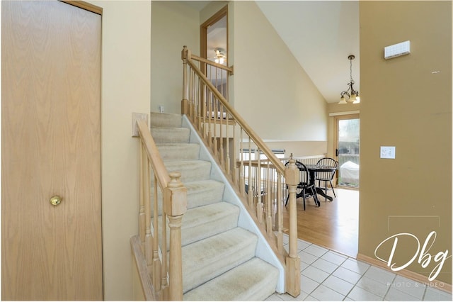 staircase with baseboards, tile patterned floors, and a high ceiling