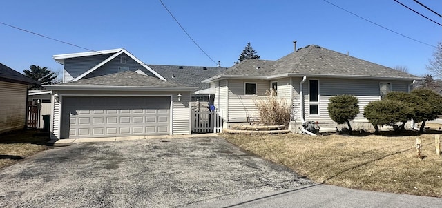 single story home featuring a garage and roof with shingles