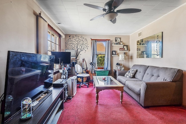 living room featuring a wealth of natural light, visible vents, ornamental molding, and carpet flooring