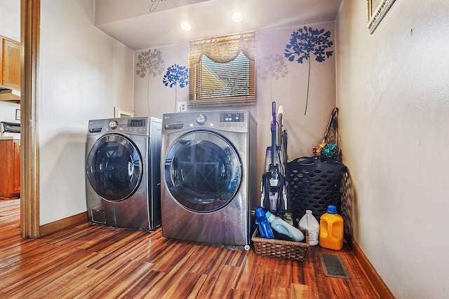 laundry room with visible vents, baseboards, laundry area, wood finished floors, and independent washer and dryer