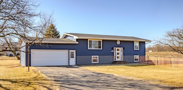 split foyer home featuring a front lawn, entry steps, aphalt driveway, fence, and an attached garage