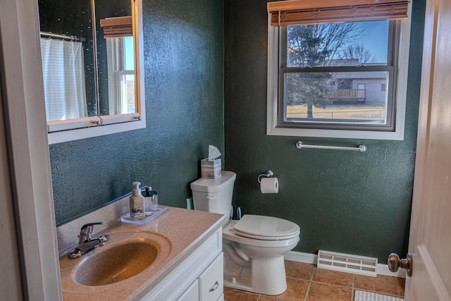 bathroom featuring visible vents, plenty of natural light, toilet, and a textured wall