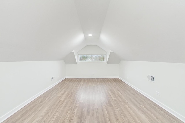 bonus room featuring visible vents, baseboards, light wood-style flooring, and vaulted ceiling