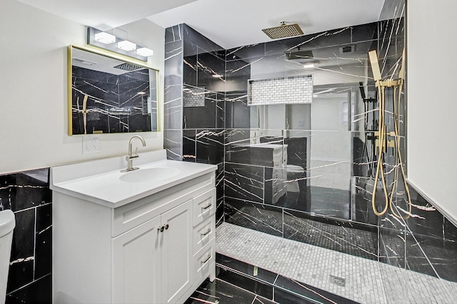 bathroom with a marble finish shower, toilet, and vanity