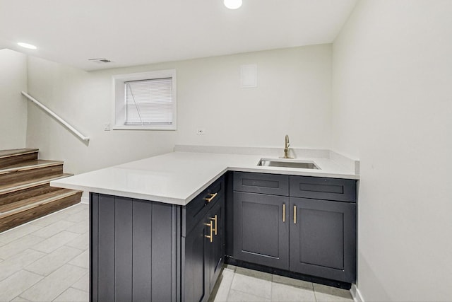 kitchen featuring visible vents, a sink, recessed lighting, a peninsula, and light countertops