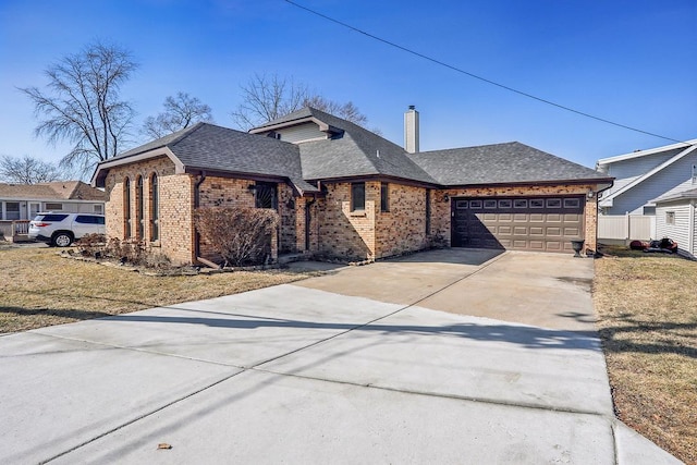 view of front of house with roof with shingles, driveway, a chimney, a garage, and brick siding