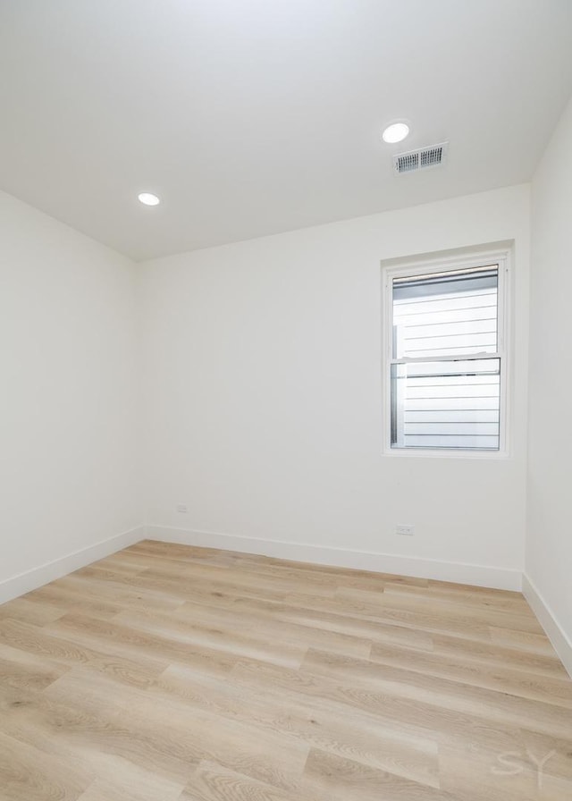 spare room with light wood finished floors, visible vents, recessed lighting, and baseboards