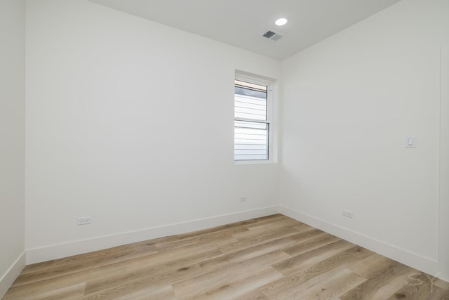 unfurnished room with visible vents, recessed lighting, light wood-type flooring, and baseboards