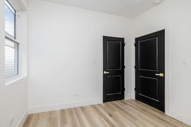 spare room featuring light wood-type flooring and baseboards