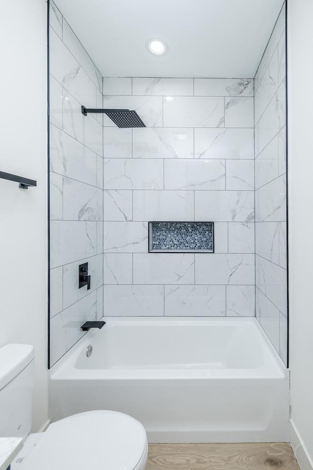 full bathroom featuring wood finished floors, toilet, and tub / shower combination