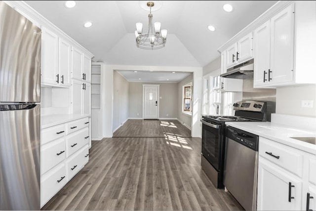 kitchen with under cabinet range hood, light countertops, lofted ceiling, stainless steel appliances, and white cabinetry