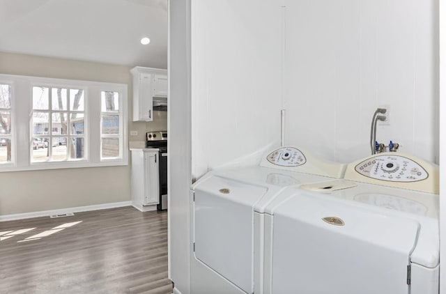 clothes washing area featuring visible vents, baseboards, dark wood finished floors, laundry area, and washer / dryer