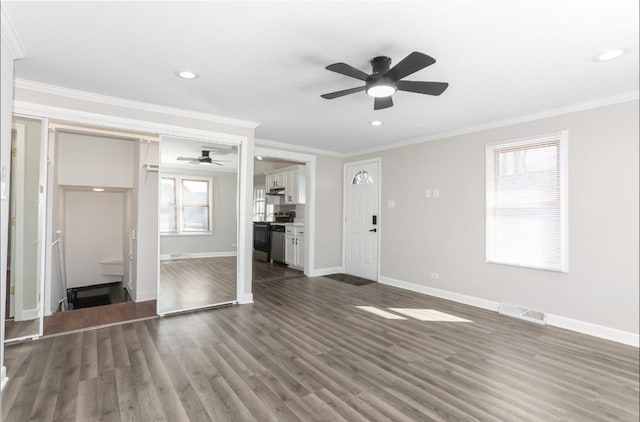 unfurnished living room featuring dark wood finished floors, baseboards, a wealth of natural light, and ornamental molding