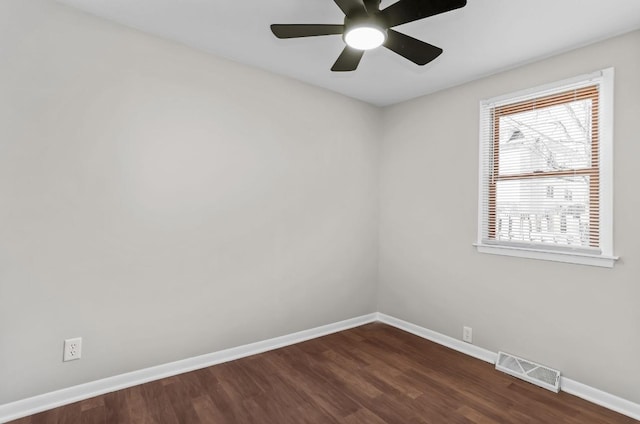 empty room featuring baseboards, visible vents, dark wood-style flooring, and ceiling fan