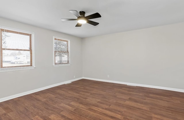 empty room with ceiling fan, baseboards, and wood finished floors