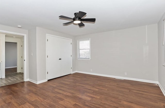 unfurnished bedroom featuring a ceiling fan, wood finished floors, baseboards, and a closet