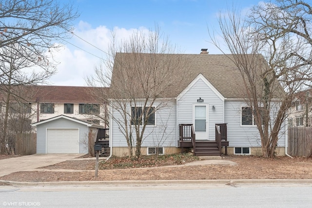 new england style home with fence, driveway, roof with shingles, an outdoor structure, and a garage