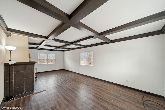 unfurnished living room featuring beam ceiling, coffered ceiling, baseboards, and dark wood-style flooring