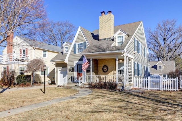 view of front of home with brick siding, a shingled roof, fence, a porch, and a chimney