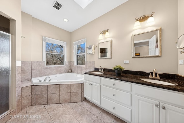 bathroom featuring tile patterned floors, a bath, visible vents, and a sink