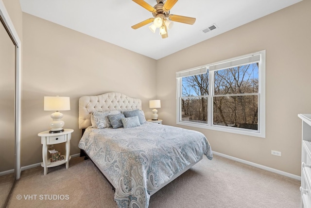 bedroom with light colored carpet, visible vents, a closet, and baseboards