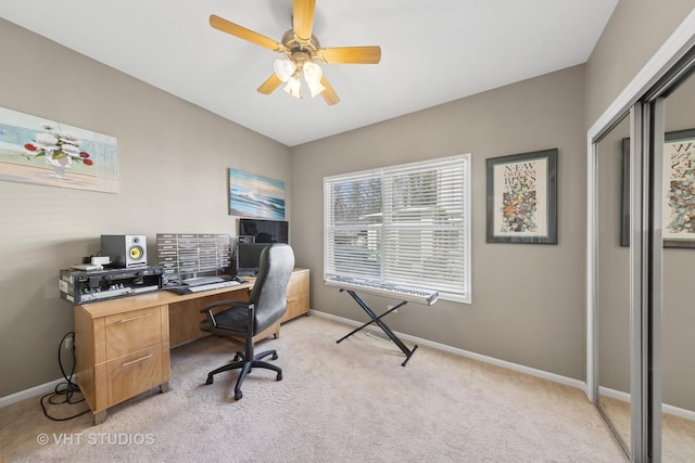 office featuring light colored carpet, baseboards, and a ceiling fan