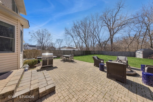 view of patio / terrace with an outbuilding, outdoor dining area, a storage shed, and a fenced backyard