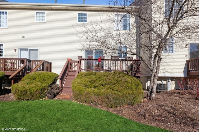 back of property with stairway, a yard, and a wooden deck