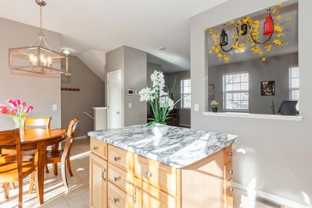 kitchen with visible vents, light brown cabinets, pendant lighting, light countertops, and a notable chandelier