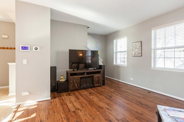 living room featuring wood finished floors, visible vents, and baseboards