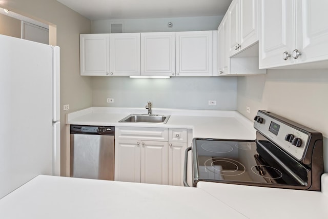 kitchen featuring visible vents, a sink, appliances with stainless steel finishes, white cabinets, and light countertops