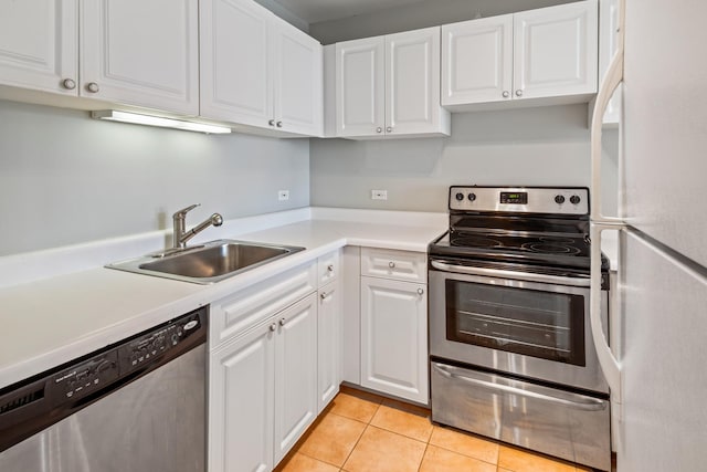 kitchen with white cabinets, stainless steel appliances, light countertops, and a sink