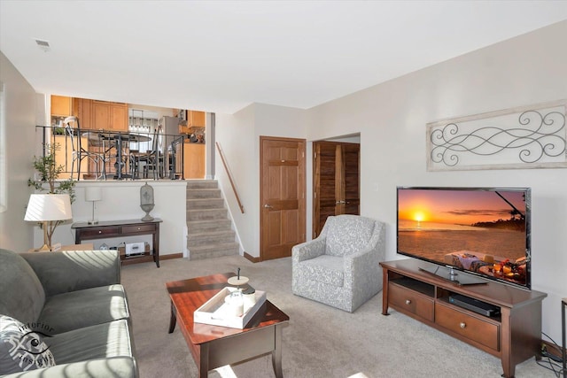 carpeted living area with visible vents, baseboards, and stairs