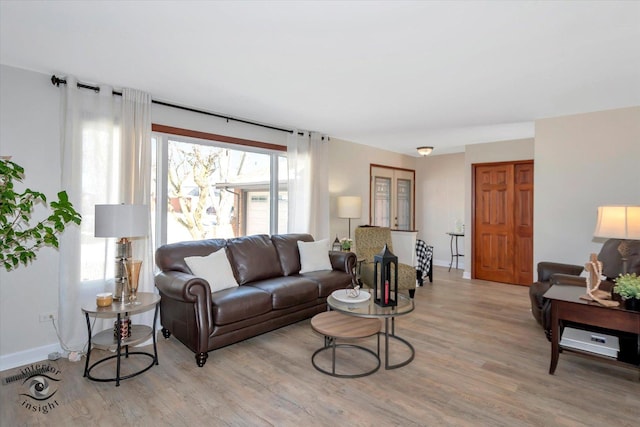 living area featuring baseboards and light wood-style floors