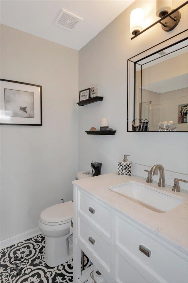 bathroom featuring visible vents, toilet, tile patterned flooring, baseboards, and vanity