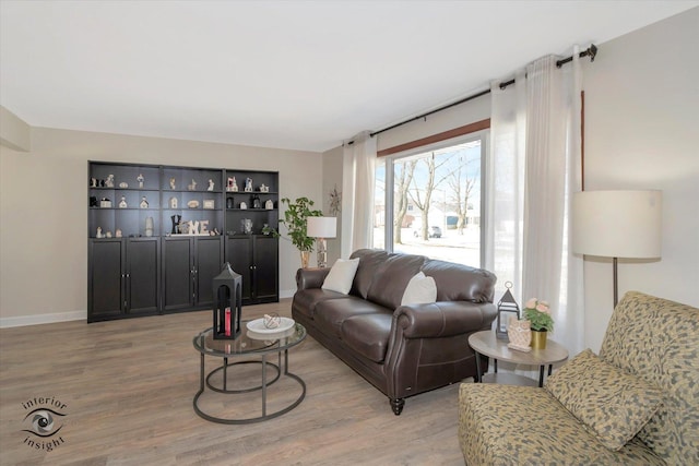 living area featuring baseboards and light wood-style floors