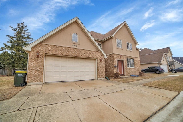 traditional home featuring a garage, brick siding, driveway, and stucco siding