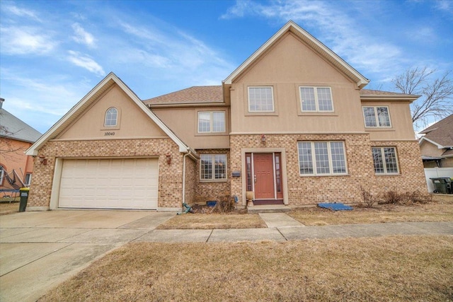 traditional-style home featuring brick siding, stucco siding, concrete driveway, and a garage