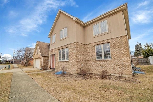 view of side of property featuring concrete driveway, an attached garage, fence, and brick siding