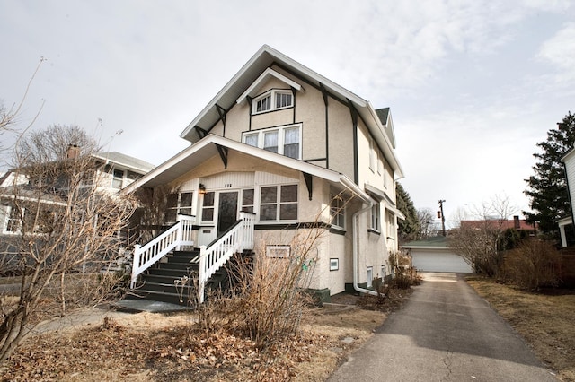 view of front of home with a garage, stucco siding, and an outdoor structure