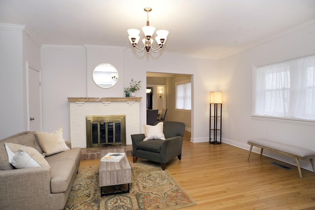 living area with baseboards, light wood-style floors, ornamental molding, and a fireplace