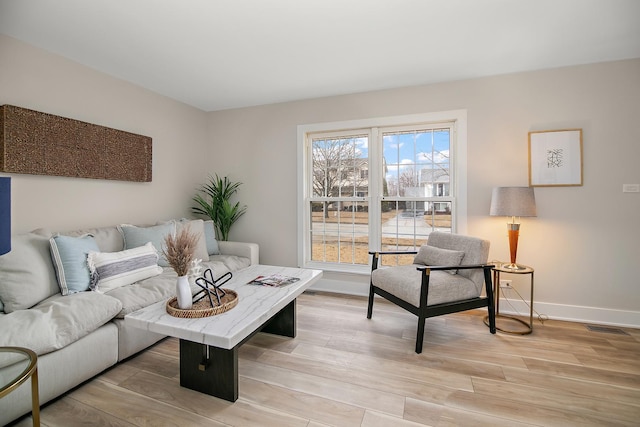 living room with light wood-style flooring and baseboards